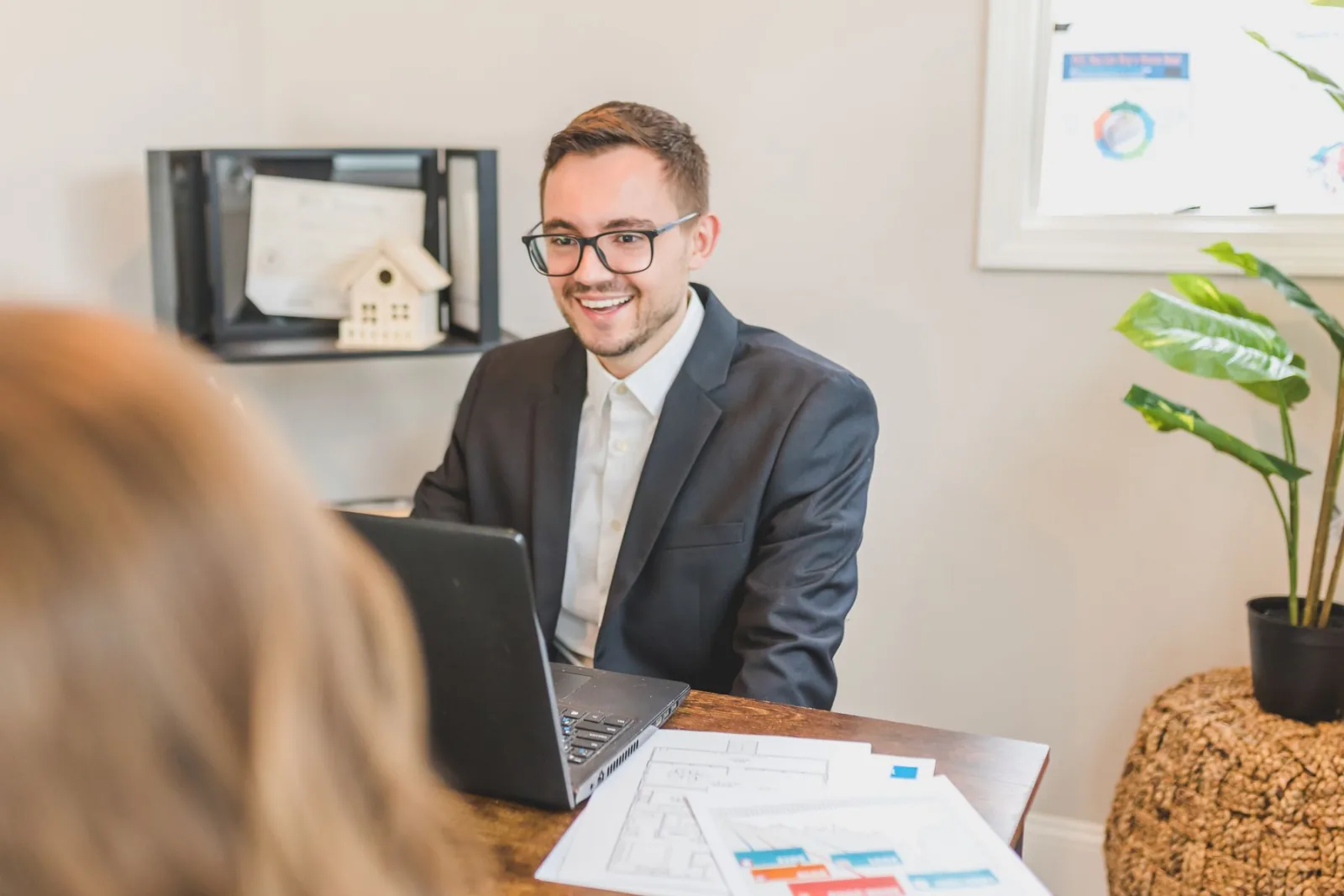 A mortgage broker meeting with a client across a desk.